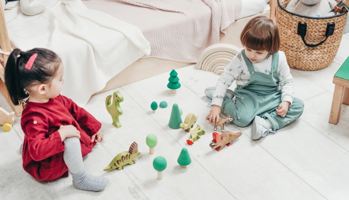 木の恐竜のおもちゃで遊ぶ子供たち